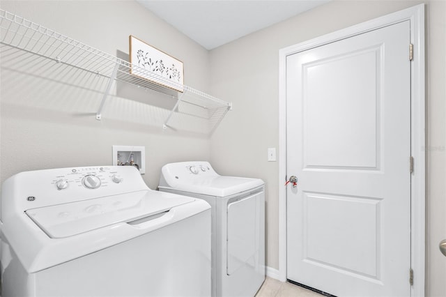 laundry room with washer and dryer, laundry area, and light tile patterned floors