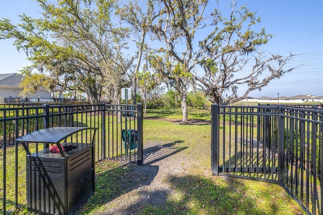 view of gate featuring a yard and fence