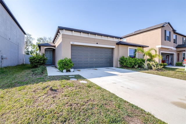 view of front of home featuring stucco siding, a front lawn, a garage, and driveway