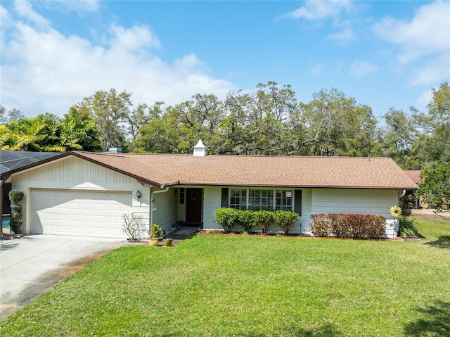 ranch-style home with driveway, a front lawn, roof with shingles, an attached garage, and a chimney