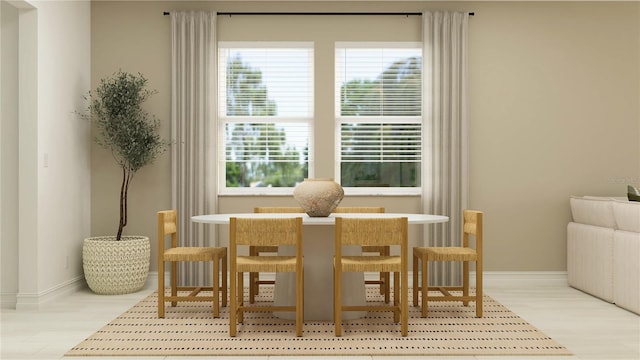 dining space featuring plenty of natural light, baseboards, and wood finished floors