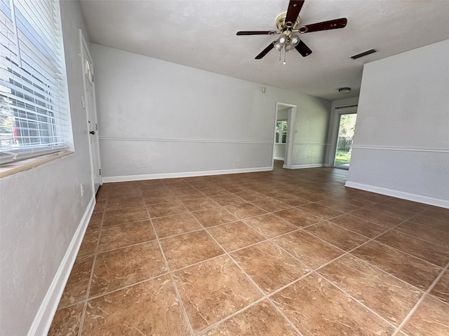 empty room featuring visible vents, baseboards, and ceiling fan