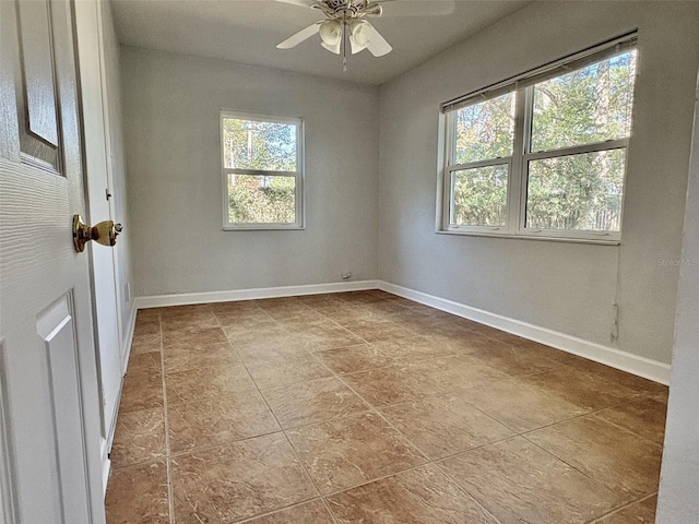 empty room featuring ceiling fan and baseboards