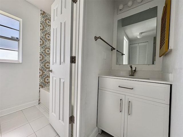 bathroom featuring baseboards, bathtub / shower combination, vanity, and tile patterned flooring