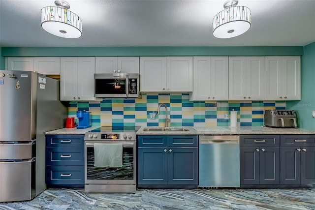 kitchen with a sink, white cabinetry, stainless steel appliances, decorative backsplash, and light stone countertops