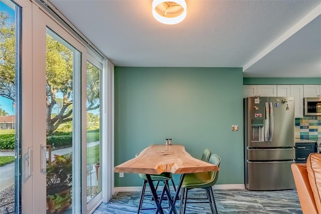 dining room featuring baseboards and a textured ceiling