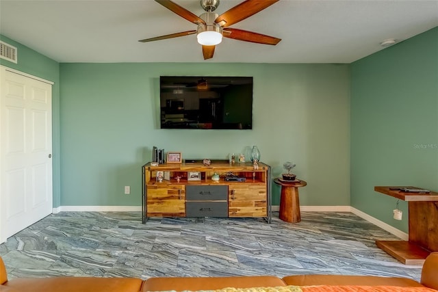 living room featuring a ceiling fan and baseboards