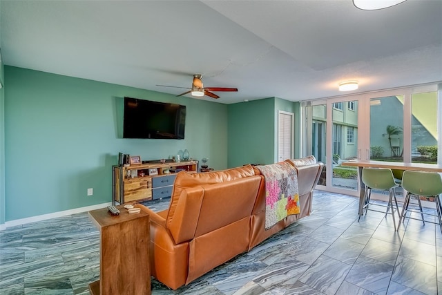 living room with ceiling fan, marble finish floor, and baseboards