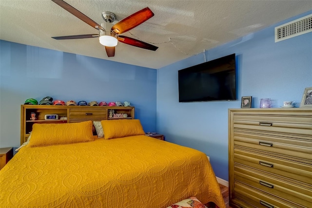 bedroom featuring visible vents, a textured ceiling, and ceiling fan