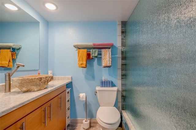 full bath featuring vanity, toilet, baseboards, and a stall shower