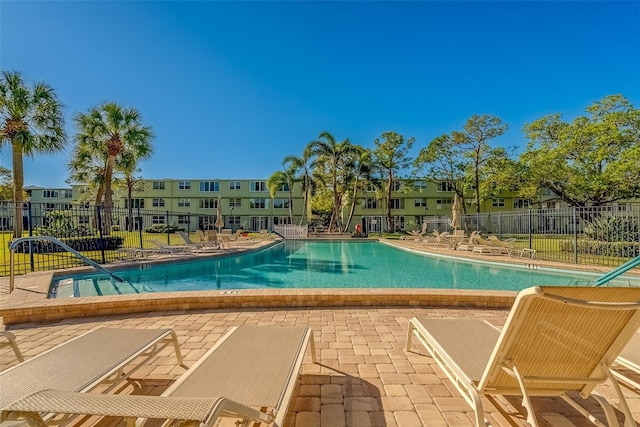 pool featuring a residential view, a patio, and fence