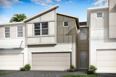 view of front of home with decorative driveway, an attached garage, and stucco siding