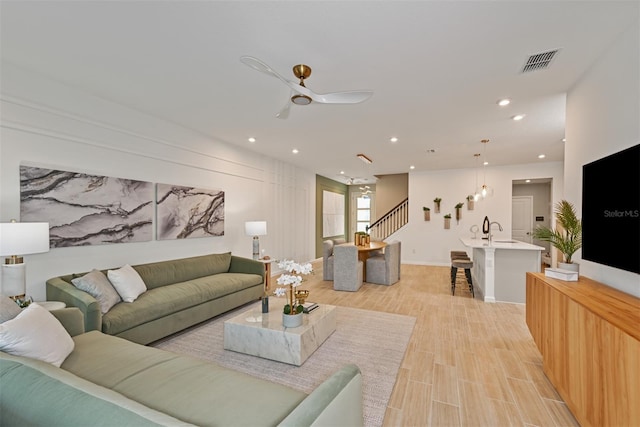 living room with stairway, recessed lighting, visible vents, and light wood finished floors