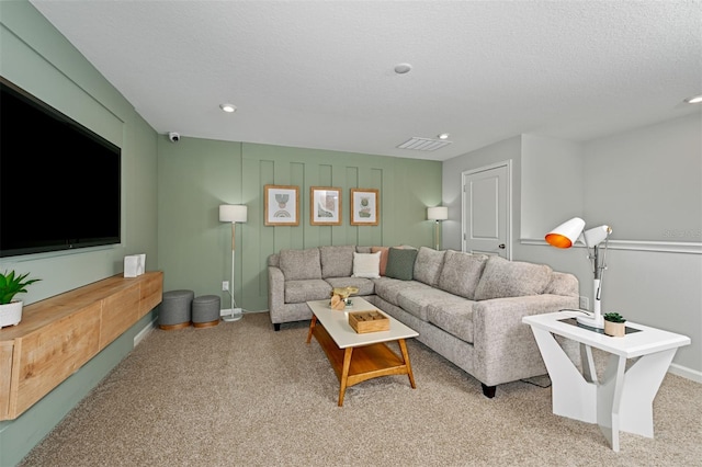 living area with a textured ceiling, recessed lighting, visible vents, and light carpet