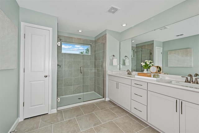 full bathroom featuring double vanity, visible vents, a shower stall, and a sink