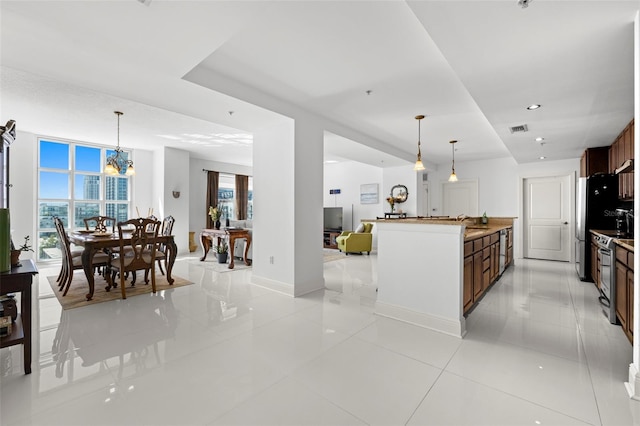 kitchen featuring a wealth of natural light, visible vents, pendant lighting, and stainless steel electric range oven