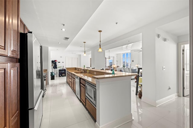 kitchen featuring visible vents, open floor plan, stone counters, appliances with stainless steel finishes, and a large island