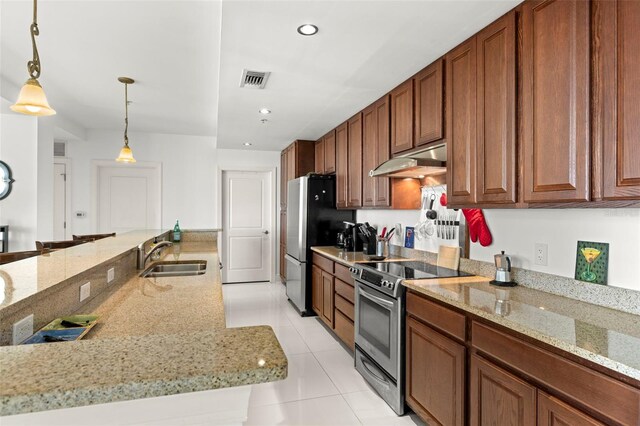 kitchen featuring visible vents, pendant lighting, under cabinet range hood, a sink, and stainless steel appliances