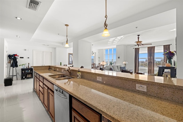 kitchen with light stone countertops, visible vents, a sink, pendant lighting, and stainless steel dishwasher