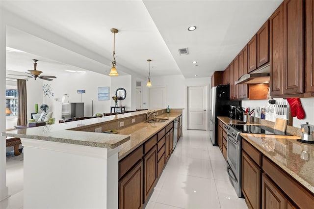 kitchen featuring visible vents, pendant lighting, under cabinet range hood, a sink, and stainless steel appliances