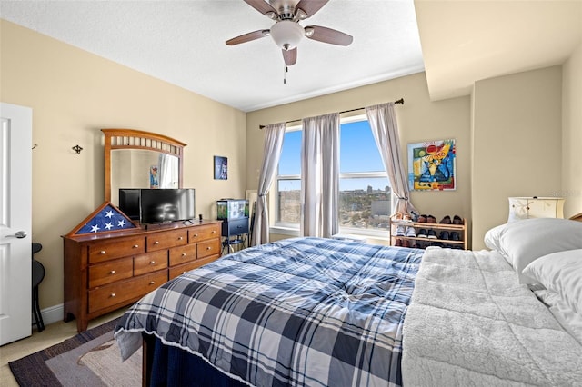 carpeted bedroom featuring ceiling fan and baseboards