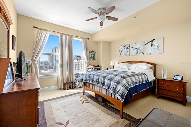 bedroom with ceiling fan, baseboards, and carpet floors