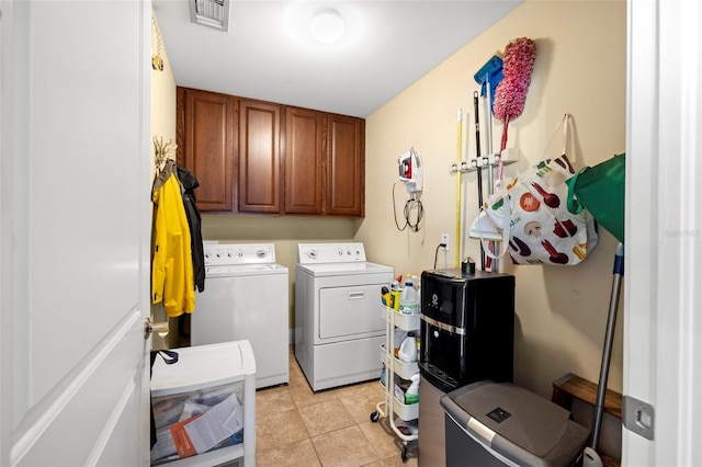 laundry room featuring visible vents, cabinet space, washing machine and dryer, and light tile patterned flooring