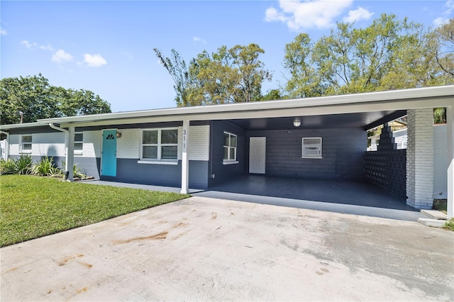 view of front facade with a carport, driveway, brick siding, and a front yard