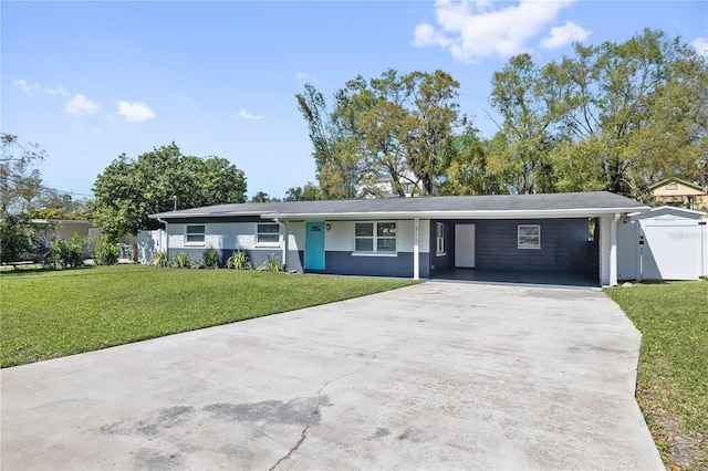 ranch-style home featuring brick siding, an attached carport, a front lawn, driveway, and a gate