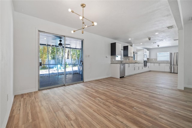 interior space featuring visible vents, baseboards, recessed lighting, light wood-style floors, and a notable chandelier