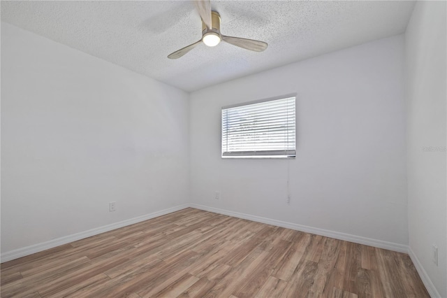 empty room featuring light wood-style flooring, a ceiling fan, and baseboards