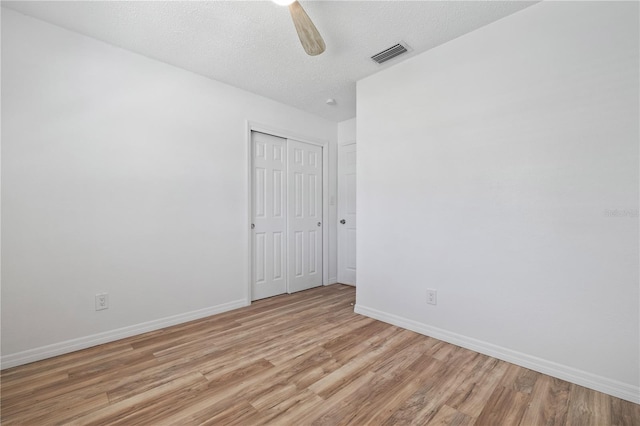 unfurnished room with light wood-style flooring, baseboards, visible vents, and ceiling fan