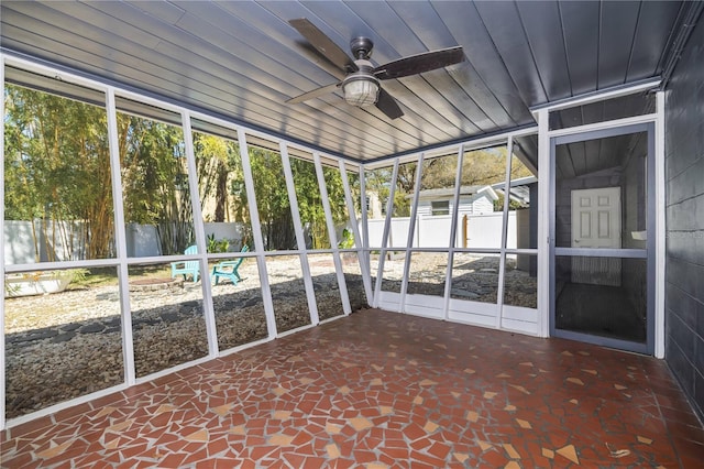 unfurnished sunroom featuring wood ceiling and ceiling fan