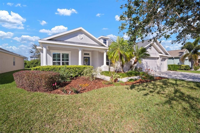 neoclassical home with a front lawn, a garage, driveway, and stucco siding