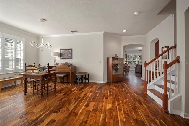 dining area with visible vents, wood finished floors, baseboards, a chandelier, and stairs