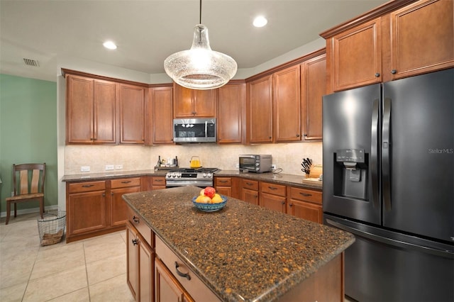 kitchen featuring backsplash, visible vents, appliances with stainless steel finishes, and brown cabinets