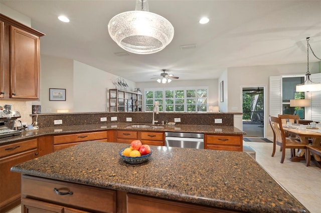 kitchen featuring a sink, brown cabinets, dishwasher, and ceiling fan