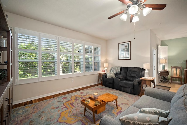 living room featuring ceiling fan, baseboards, and wood finished floors