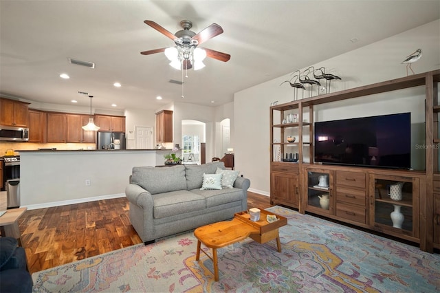 living room with visible vents, wood finished floors, recessed lighting, arched walkways, and ceiling fan