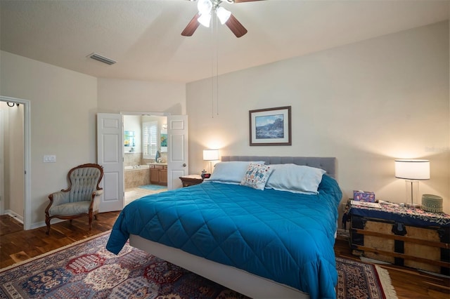 bedroom featuring wood finished floors, baseboards, visible vents, ceiling fan, and connected bathroom