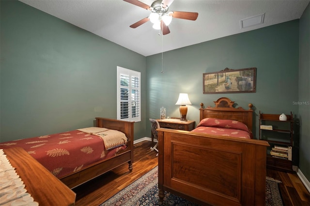 bedroom with visible vents, ceiling fan, baseboards, and wood finished floors