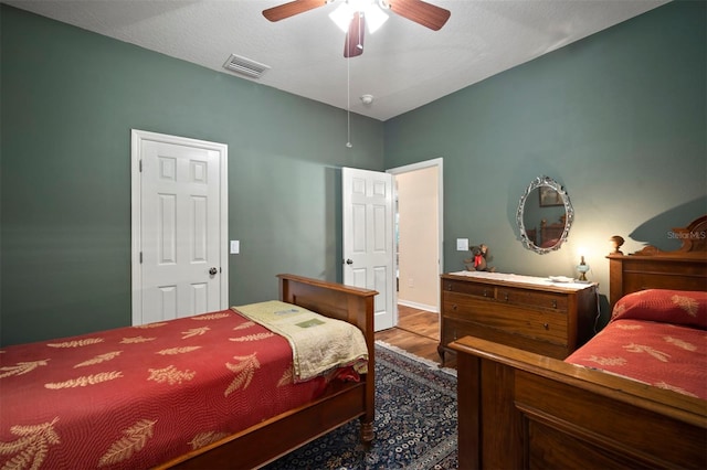 bedroom with visible vents, ceiling fan, and wood finished floors