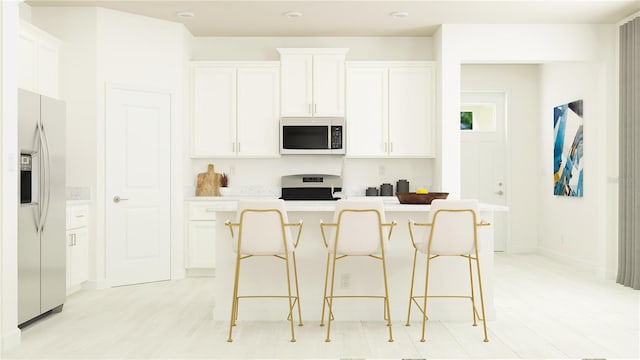 kitchen featuring a center island, white cabinetry, stainless steel appliances, a breakfast bar area, and light countertops