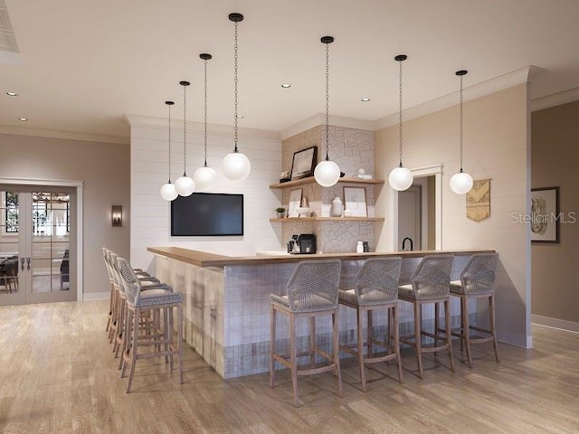 bar featuring ornamental molding, pendant lighting, baseboards, and wood finished floors