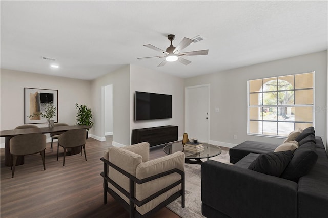 living room with visible vents, ceiling fan, dark wood-type flooring, and baseboards