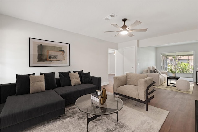 living area featuring wood finished floors, visible vents, and ceiling fan