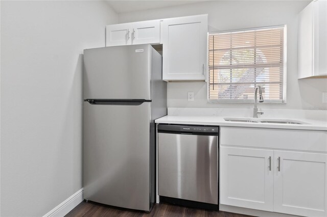 kitchen with a sink, stainless steel appliances, white cabinets, and light countertops