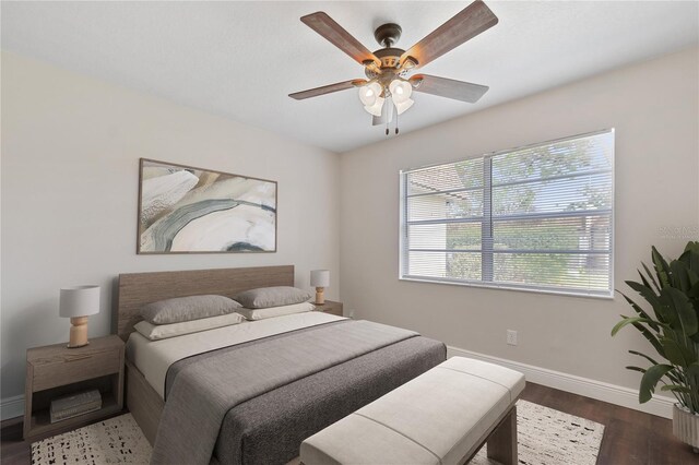 bedroom featuring a ceiling fan, baseboards, and wood finished floors