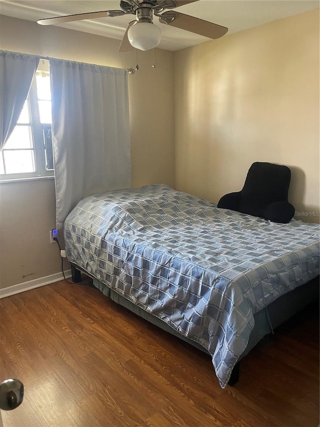 bedroom with baseboards, wood finished floors, and a ceiling fan