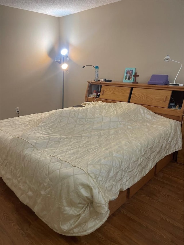 bedroom with a textured ceiling and wood finished floors